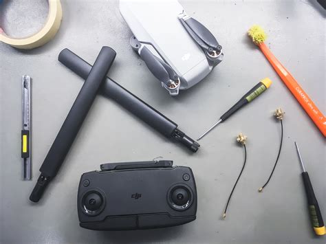 Mavic Mini távirányítója átalakítás előtt, és mellette az új antennacsatlakozók és antennák.