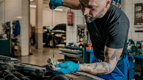 Szerelő ellenőrzi a kipufogórendszert